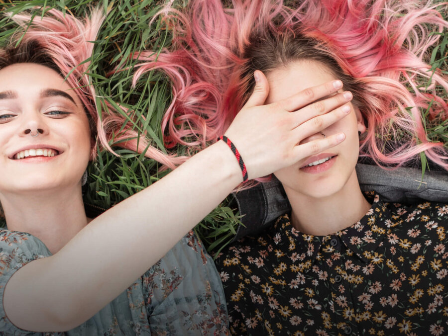 Young woman covering her friends eyes