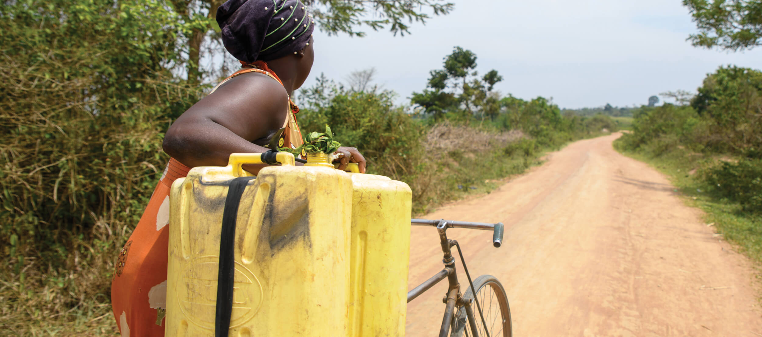 Image of a woman carrying water on a bicycle