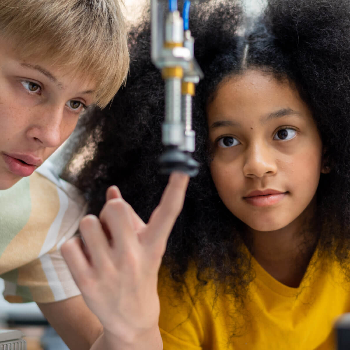 Close up of two young people looking at a science experiment